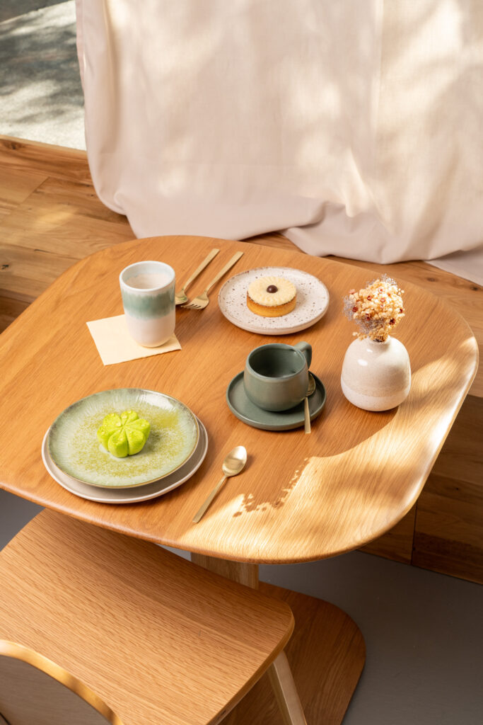 photo poétique d'une table dréssée à la pâtisseie de Lausanne, souché de soleil et deux belles pâtisseries
